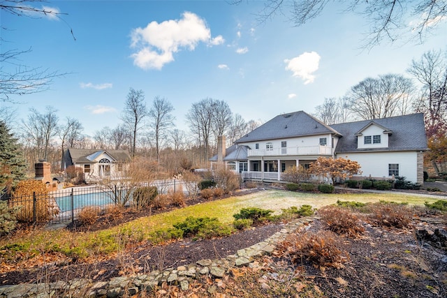 rear view of house with a fenced in pool