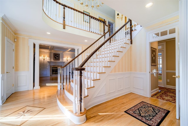 stairway with hardwood / wood-style floors and ornamental molding