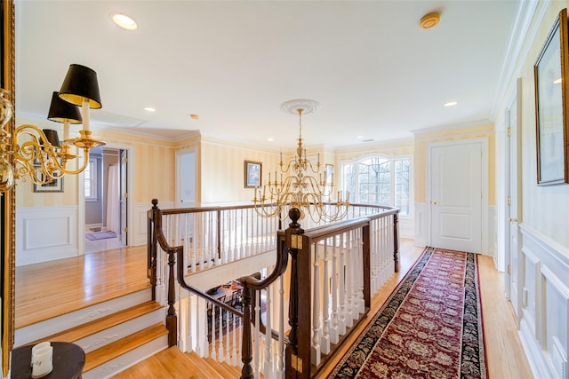 hall featuring a chandelier, crown molding, and light hardwood / wood-style flooring