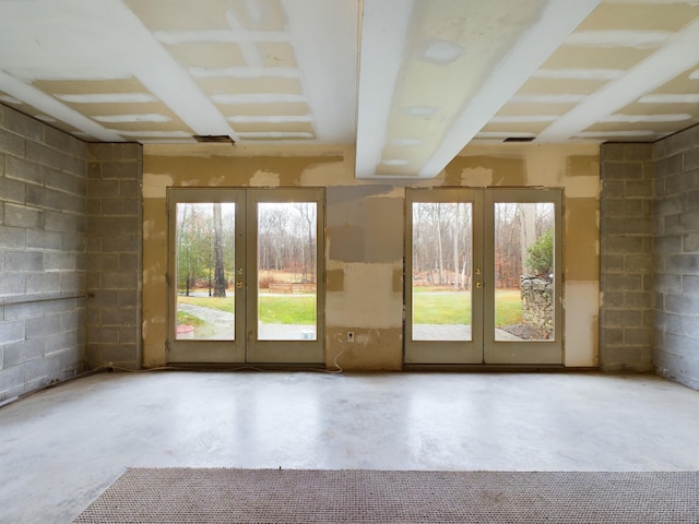 doorway featuring a healthy amount of sunlight, french doors, and concrete floors