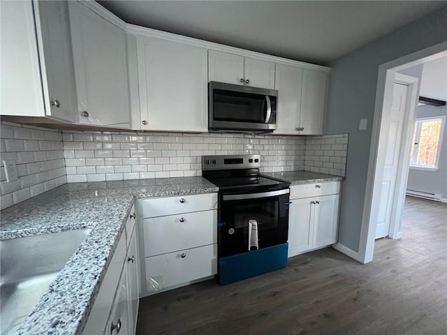 kitchen with light stone countertops, tasteful backsplash, stainless steel appliances, dark wood-type flooring, and white cabinetry