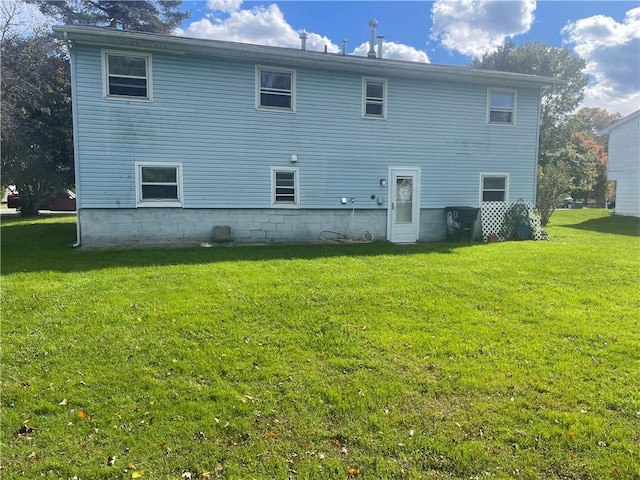 rear view of property featuring a lawn