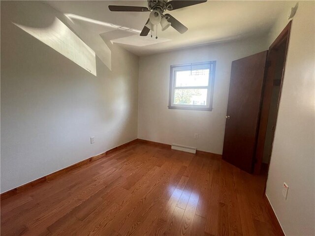 empty room with ceiling fan, hardwood / wood-style floors, and a baseboard radiator