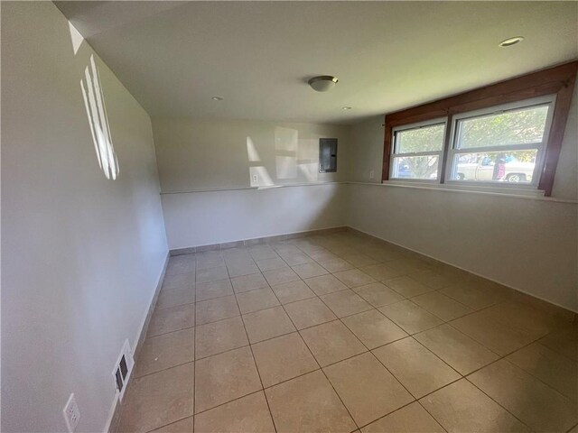 empty room featuring light tile patterned floors and electric panel