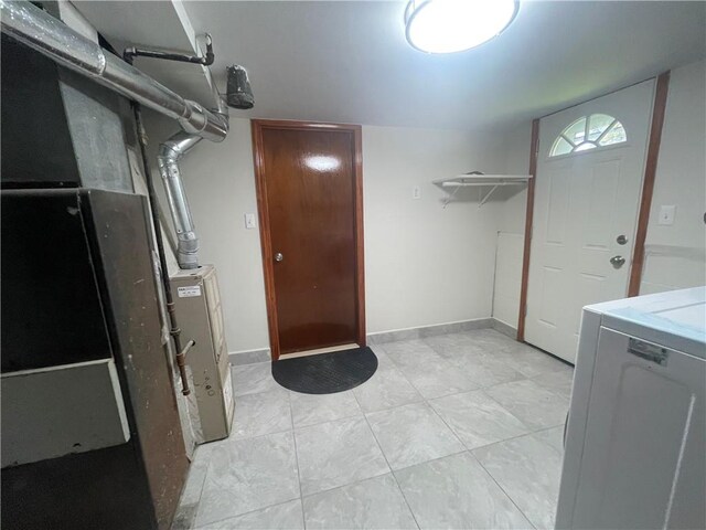 laundry room with washer / dryer, light tile patterned floors, and heating unit