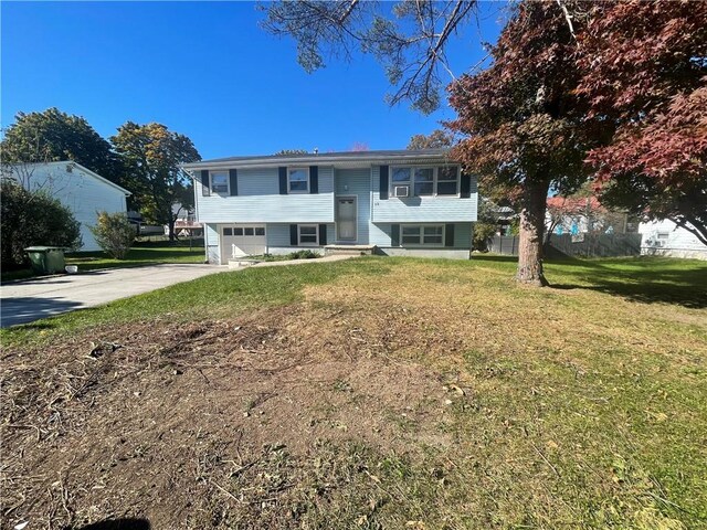 bi-level home with a garage and a front lawn