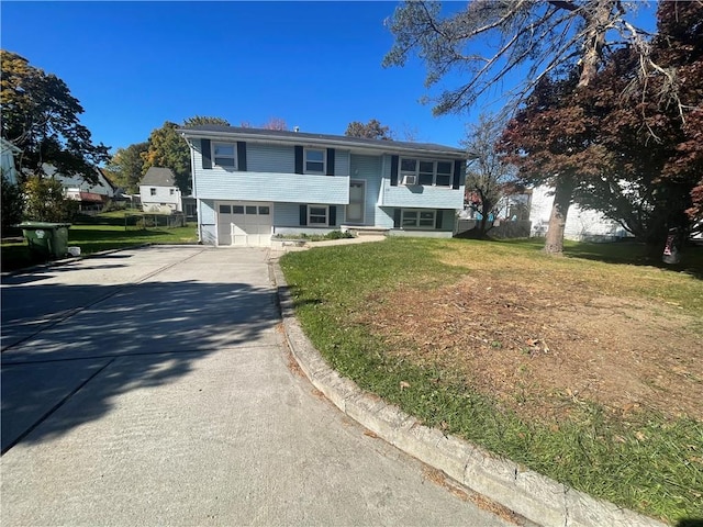 bi-level home with a garage and a front lawn