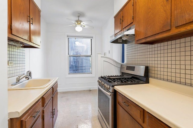 kitchen featuring tasteful backsplash, ceiling fan, sink, and stainless steel range with gas stovetop