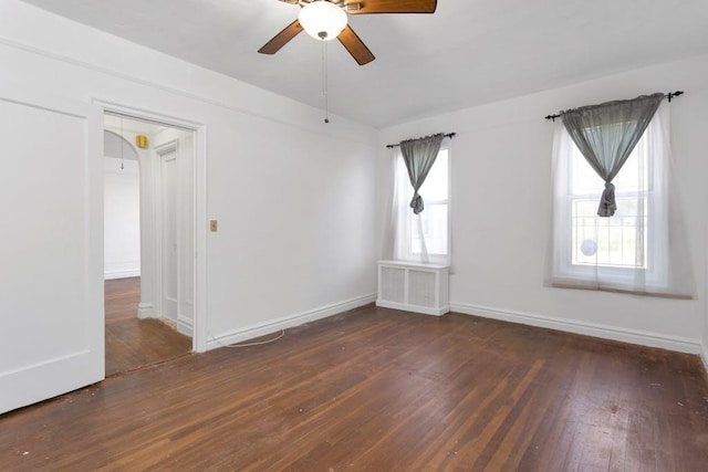 empty room with dark hardwood / wood-style floors, ceiling fan, and plenty of natural light