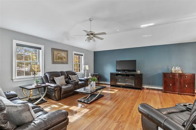 living area with a baseboard heating unit, lofted ceiling, light wood-style floors, and ceiling fan