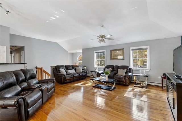 living room with lofted ceiling, light wood-style flooring, baseboard heating, and ceiling fan