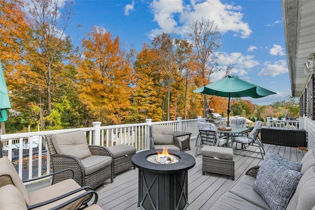 deck with an outdoor living space with a fire pit