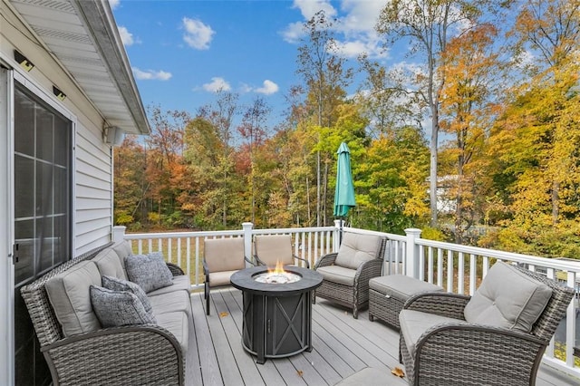 deck featuring an outdoor living space with a fire pit