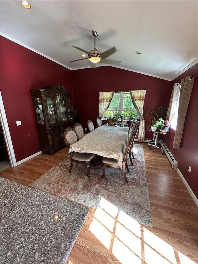 dining area featuring ceiling fan, baseboard heating, crown molding, hardwood / wood-style floors, and vaulted ceiling