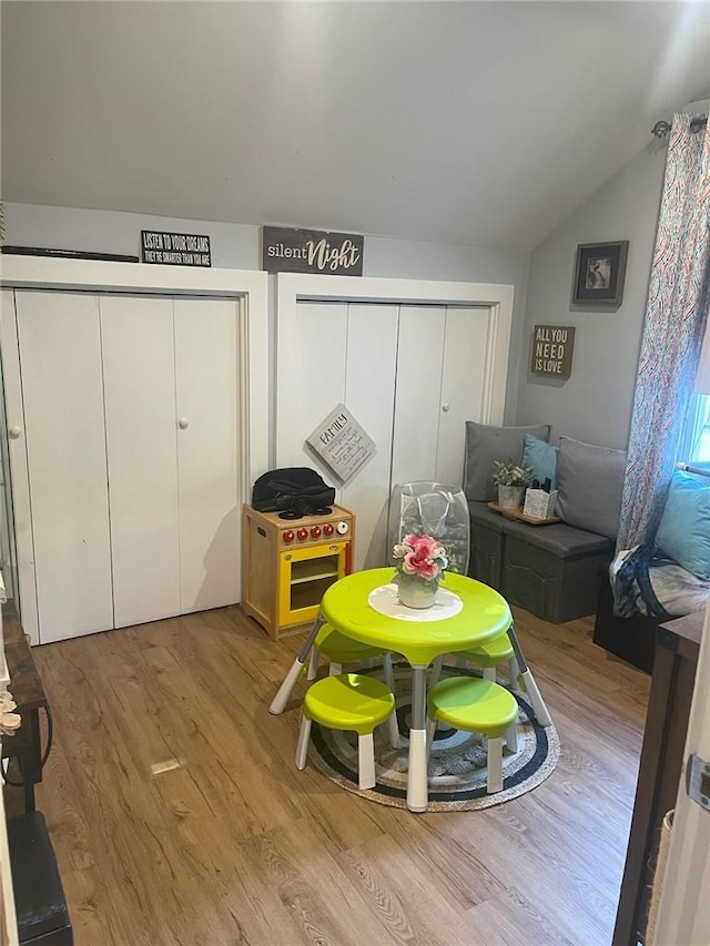 playroom with lofted ceiling and light wood-type flooring