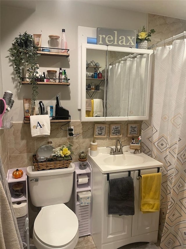 bathroom with decorative backsplash, toilet, curtained shower, and sink