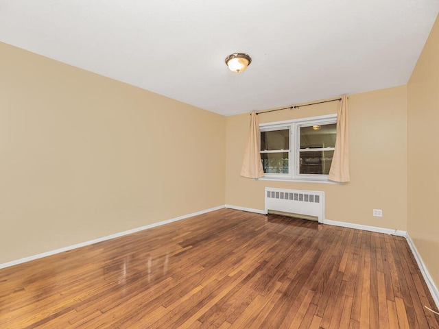 unfurnished room with hardwood / wood-style floors and radiator