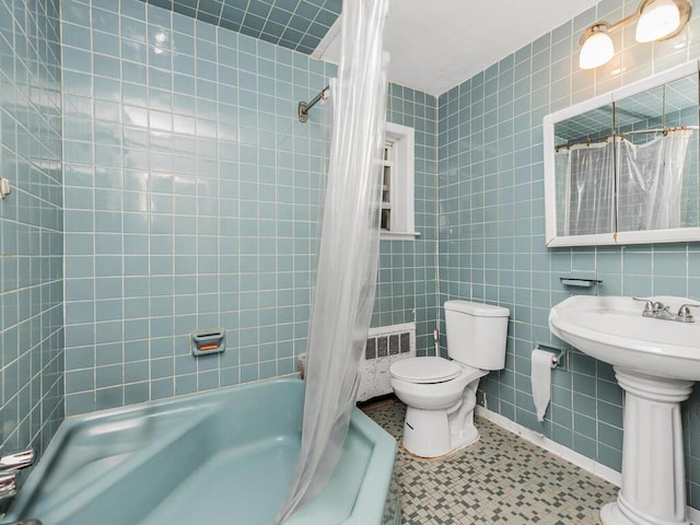 full bathroom with tile patterned floors, shower / bath combo with shower curtain, sink, tile walls, and toilet