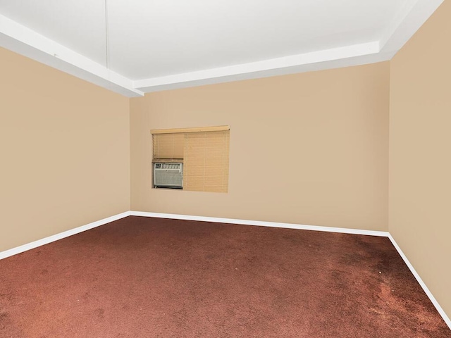 carpeted spare room featuring a raised ceiling and cooling unit