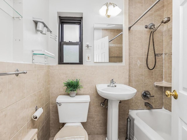 full bathroom with sink, tiled shower / bath combo, tile walls, and toilet