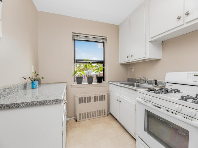 kitchen with white cabinetry, radiator, gas range gas stove, and sink