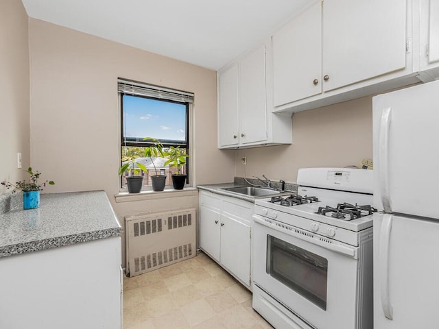 kitchen with white cabinetry, white appliances, sink, and radiator