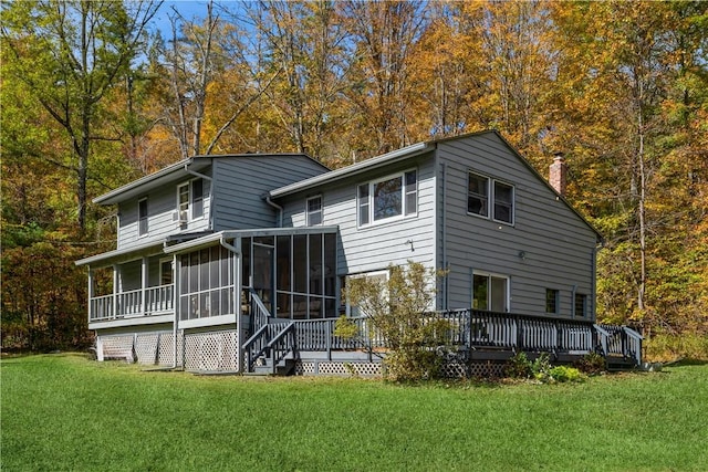 rear view of house with a wooden deck, a sunroom, and a yard