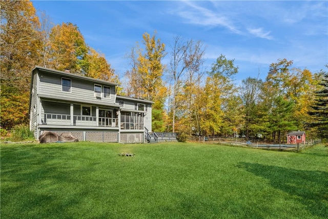 rear view of property featuring a sunroom and a yard