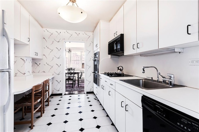 kitchen with sink, white cabinetry, and black appliances