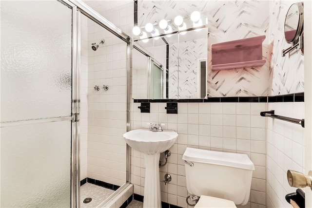 bathroom with walk in shower, sink, tile walls, and toilet