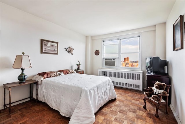 bedroom with radiator, cooling unit, and parquet flooring