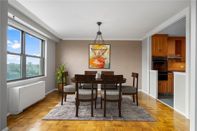 dining room with light parquet flooring, radiator, and ornamental molding