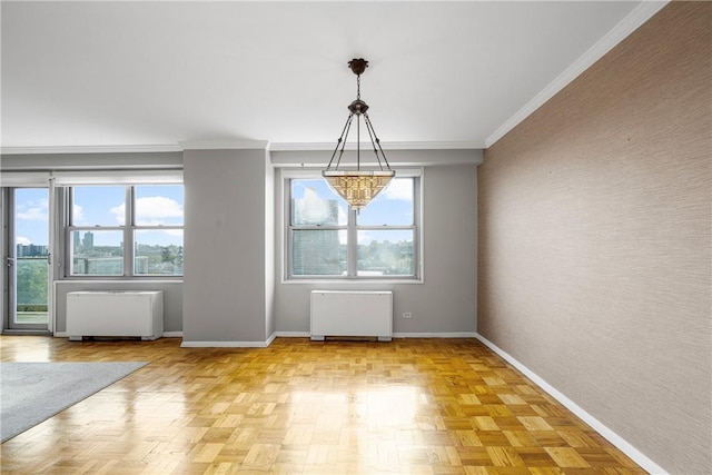 unfurnished dining area featuring radiator heating unit, light parquet floors, crown molding, and a notable chandelier