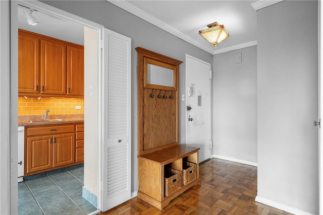 mudroom featuring dark parquet floors, ornamental molding, and sink