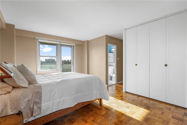 bedroom with ensuite bathroom and light parquet floors