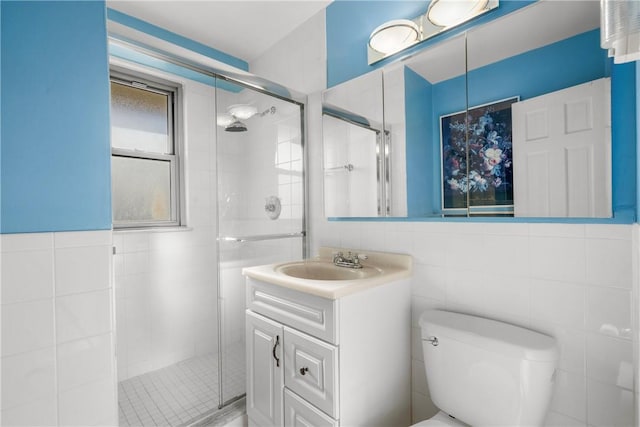 bathroom featuring vanity, tile walls, and toilet