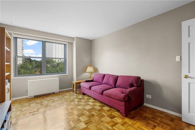 living room featuring radiator heating unit and light parquet flooring