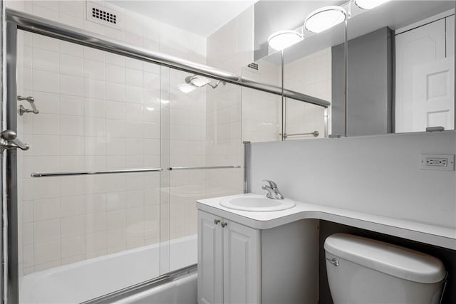 full bathroom featuring vanity, toilet, and combined bath / shower with glass door