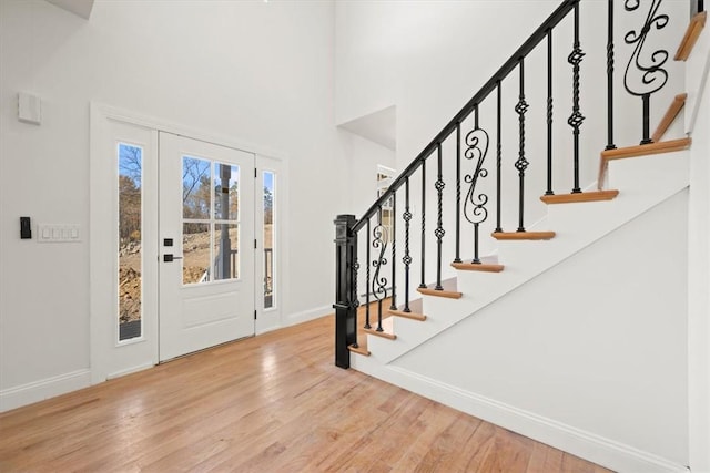 foyer entrance with a high ceiling and light hardwood / wood-style flooring