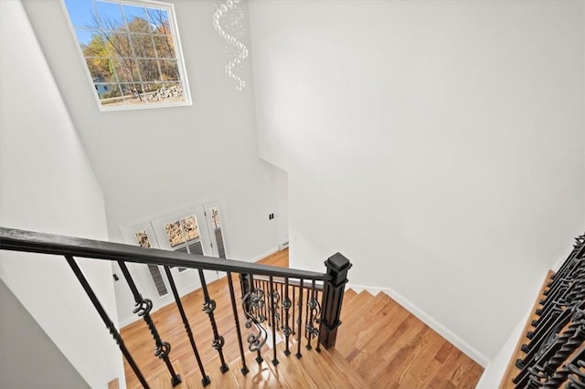 staircase with a chandelier and wood-type flooring