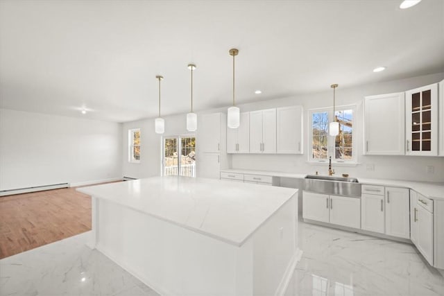 kitchen with white cabinets, a center island, and a wealth of natural light