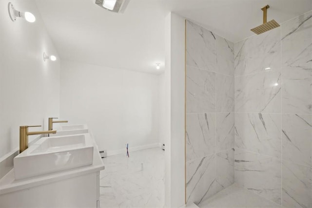 bathroom featuring tiled shower and vanity