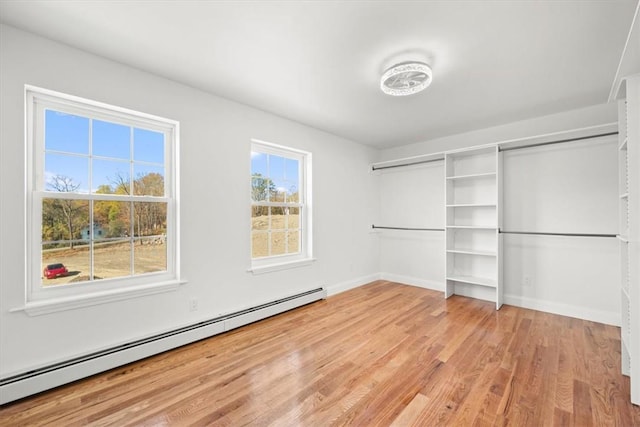 spacious closet featuring light wood-type flooring and a baseboard radiator