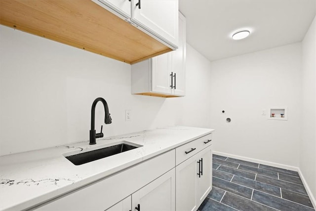 laundry room featuring sink, cabinets, dark tile patterned flooring, and washer hookup