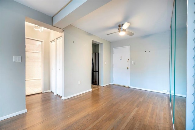 empty room with hardwood / wood-style floors and ceiling fan