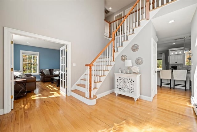 stairway featuring wood-type flooring and a baseboard heating unit