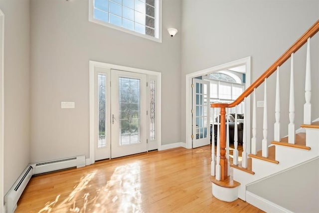 foyer with hardwood / wood-style floors, plenty of natural light, and a high ceiling