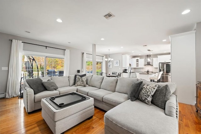 living room featuring a chandelier and light hardwood / wood-style flooring