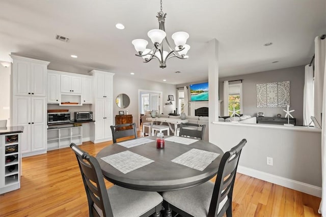 dining space featuring an inviting chandelier and light wood-type flooring