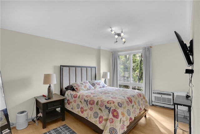 bedroom featuring an AC wall unit and light hardwood / wood-style flooring